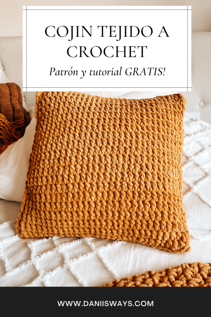 Una imagen de Pinterest con un cojín tejido a crochet de color amarillo sobre una cama blanca y en el texto se lee "cojín tejido a crochet, patrón y tutorial gratis"