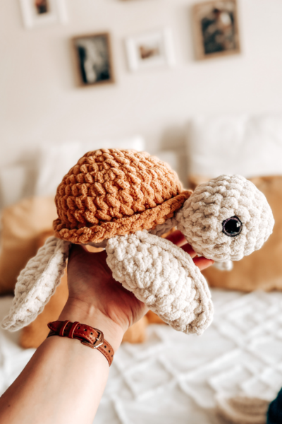 Una tortuga teida a crochet sobre una mano